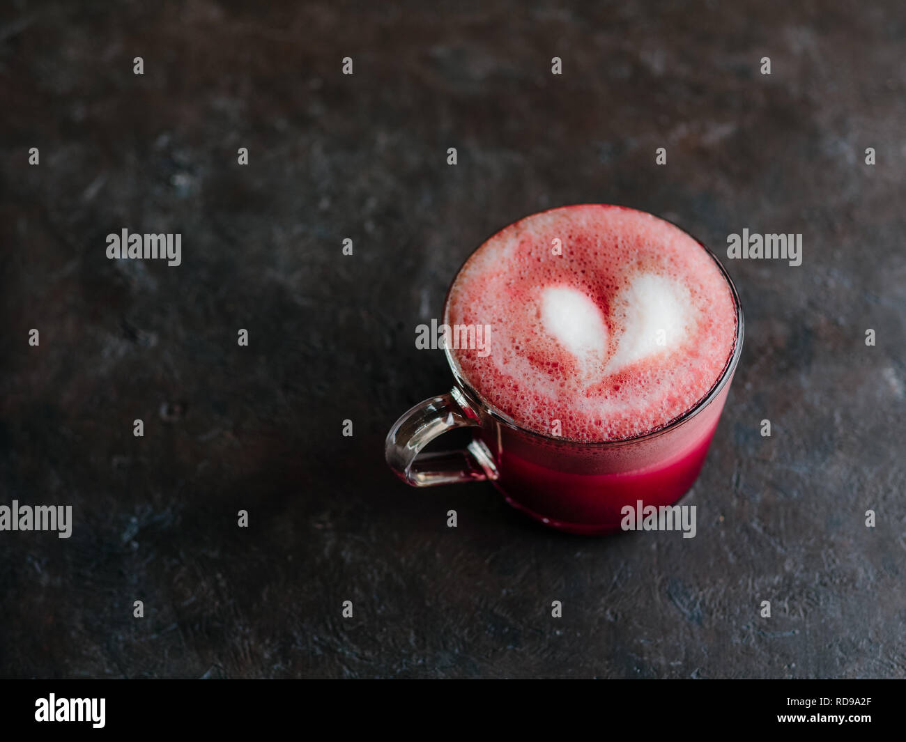 Trendgetränk: Pink Red velvet Latte. Rote Beete Cappuccino oder Latte in Glas Schale auf schwarzen Hintergrund. Kopieren Sie Platz für Text. Stockfoto