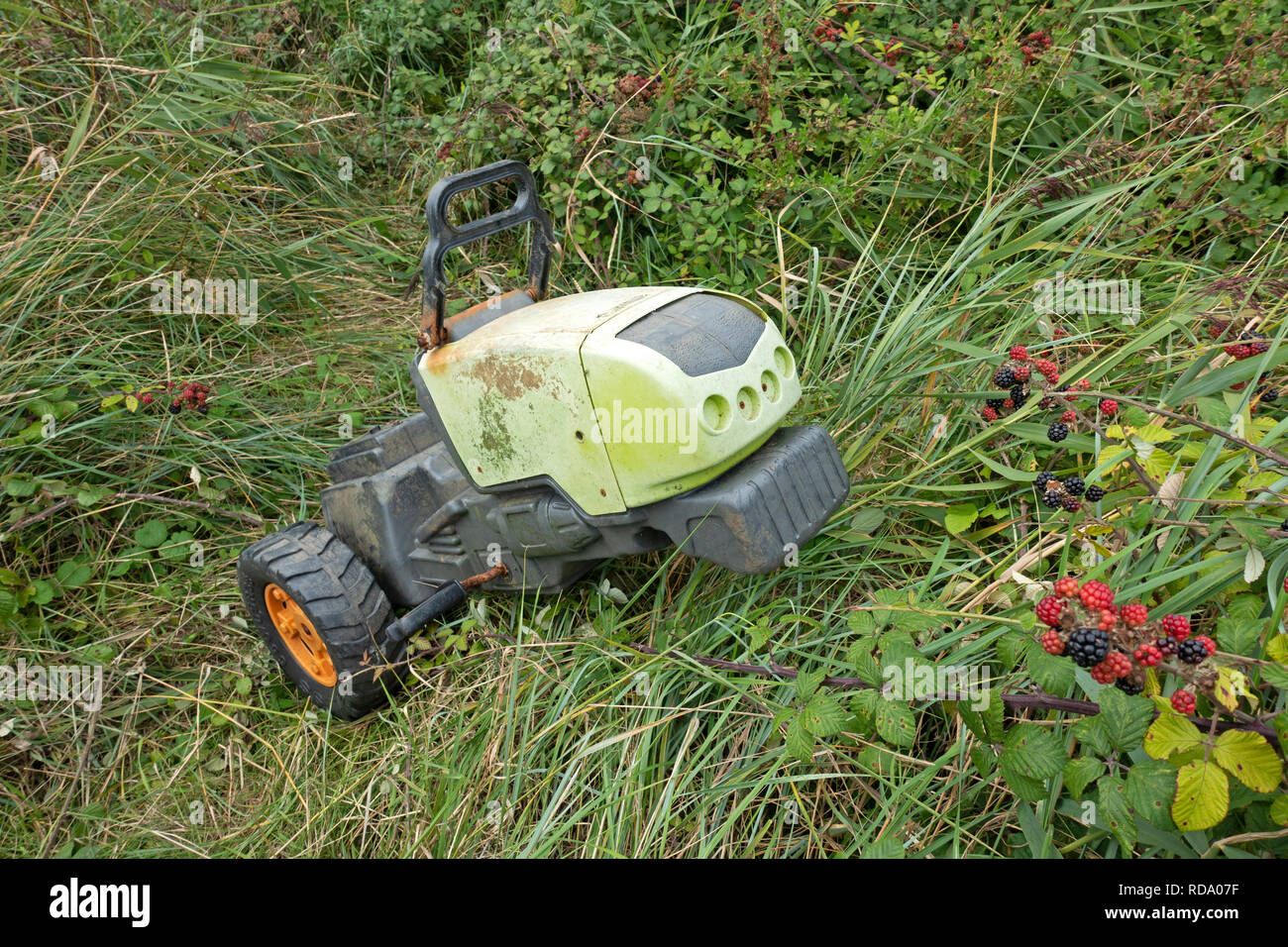 Brocken Childrens Ride-on Traktor gedumpten am Straßenrand Stockfoto
