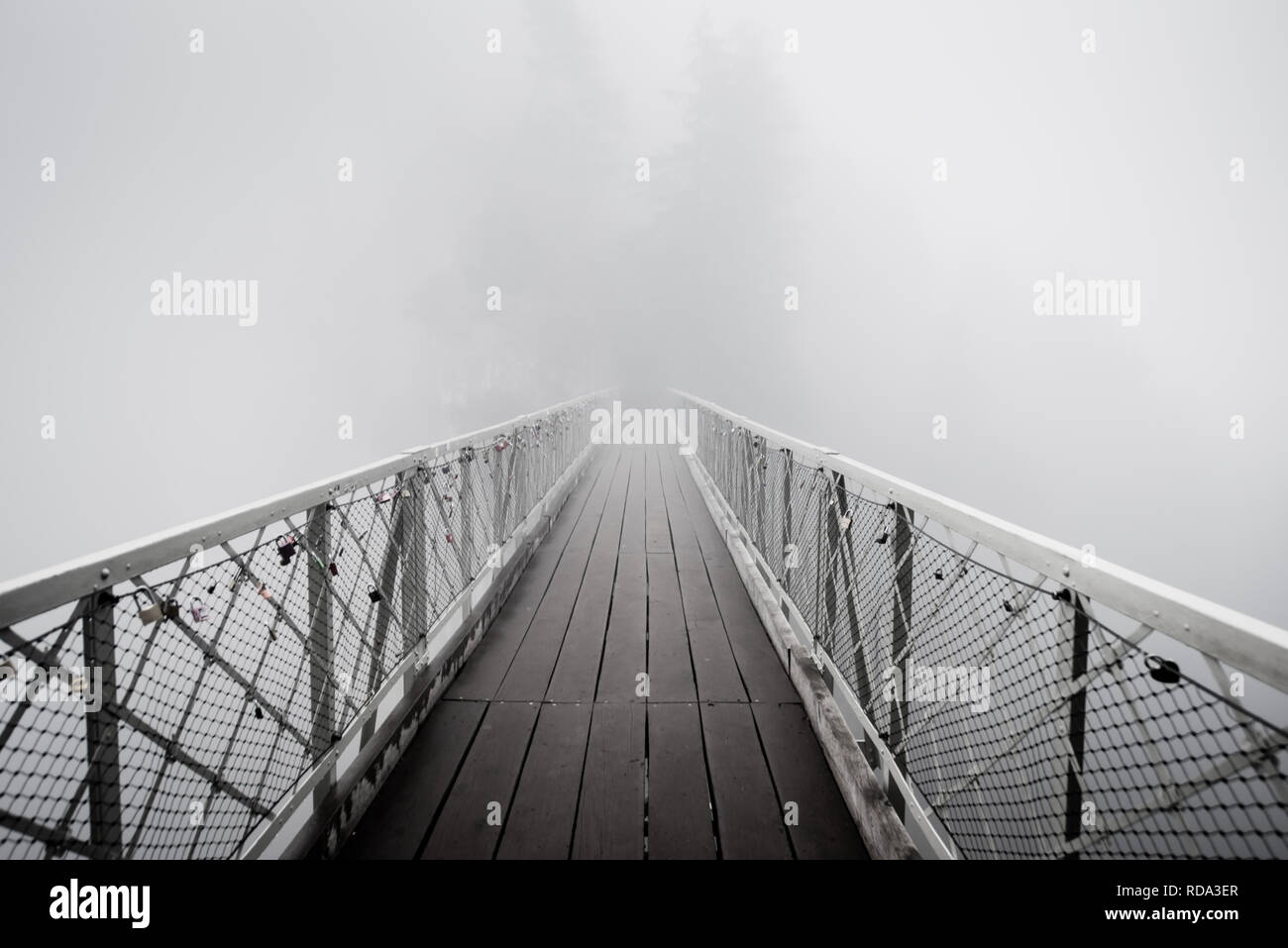 Konzept Bild von Großbritannien Brexit & Reisen ins Unbekannte mit Bedingungen und Einschränkungen durch die Vorhängeschlösser symbolisiert. Holzbrücke im dichten Nebel Stockfoto