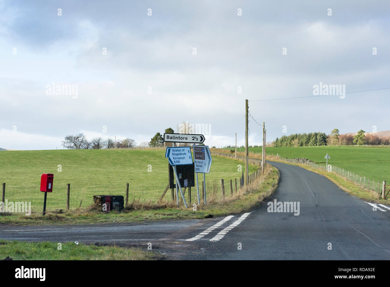 Ländliche Straße in Perthshire, Schottland. Straßenschilder und eine Royal Mail roten Briefkasten Stockfoto