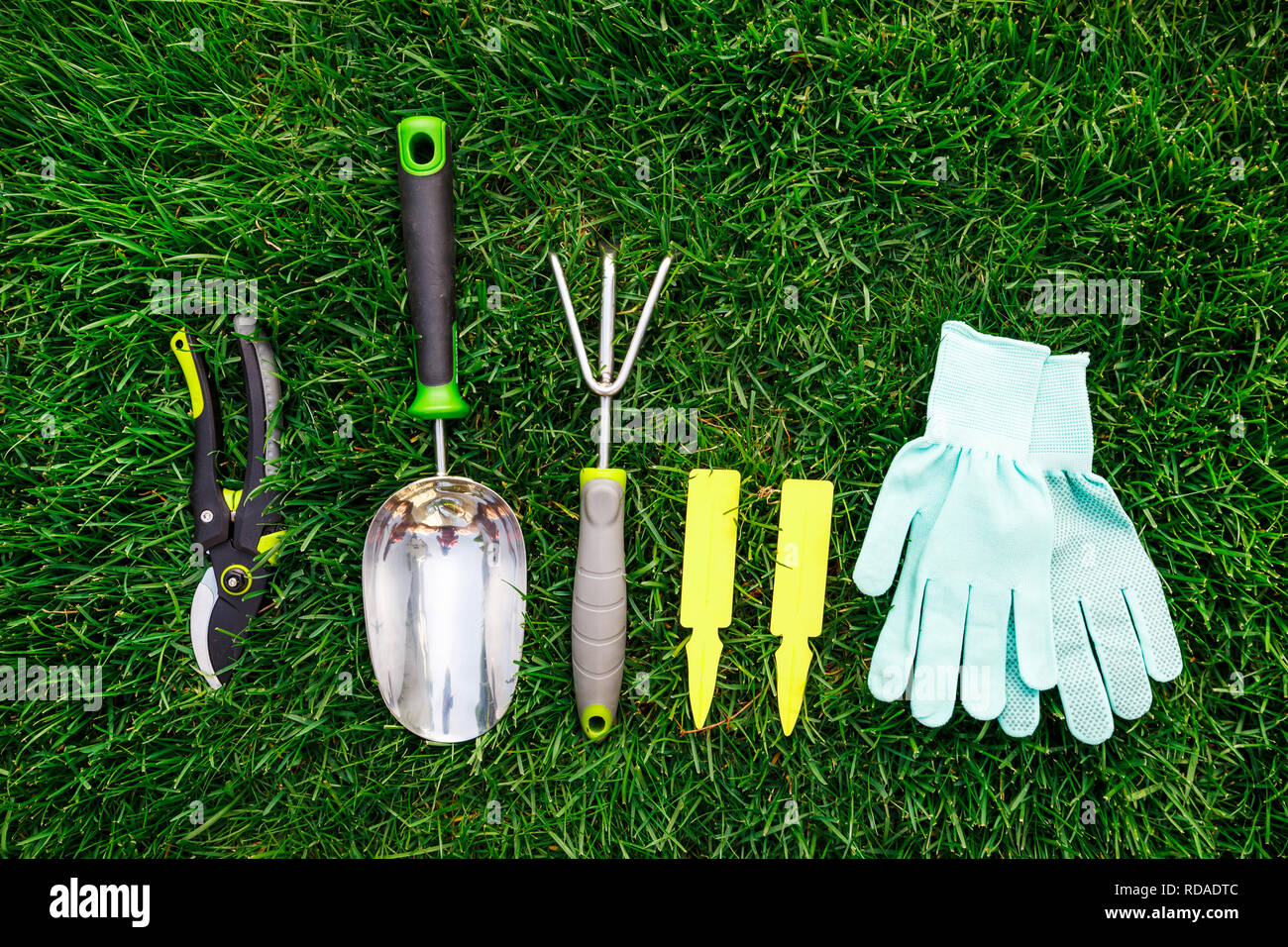 Im Garten arbeitende Werkzeuge und Geräte aus der Nähe auf dem grünen Rasen, Garten und Hobby. Stockfoto