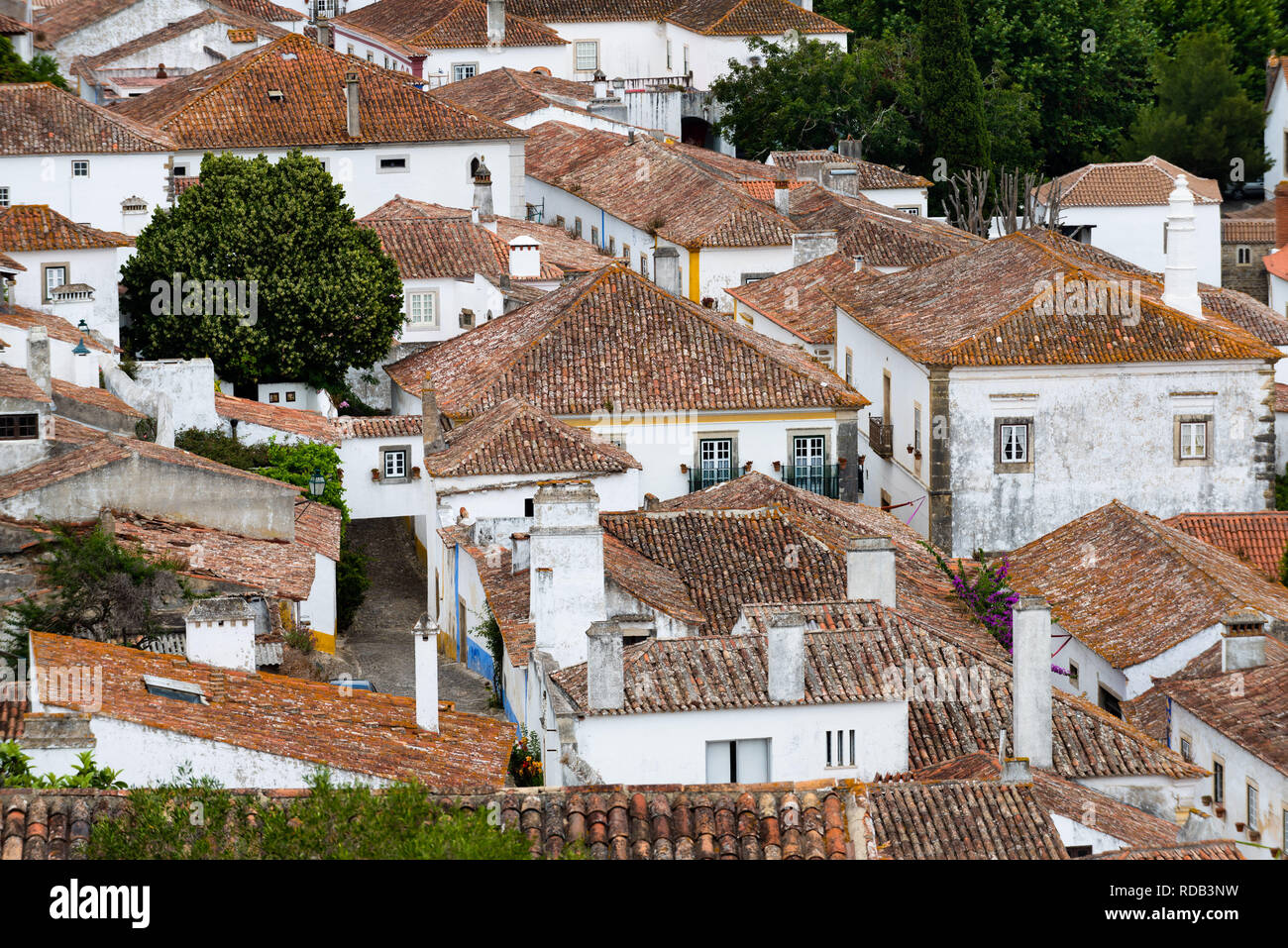 Weiße Häuser mit terrakottafarbenen Dachziegeln in touristischen Dorf Obidos Stockfoto