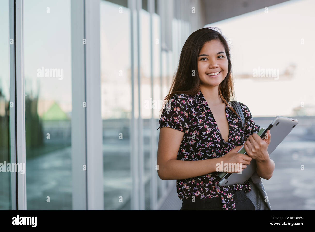 Junge asiatische Studentin Lächeln beim Stehen auf dem Campus Stockfoto