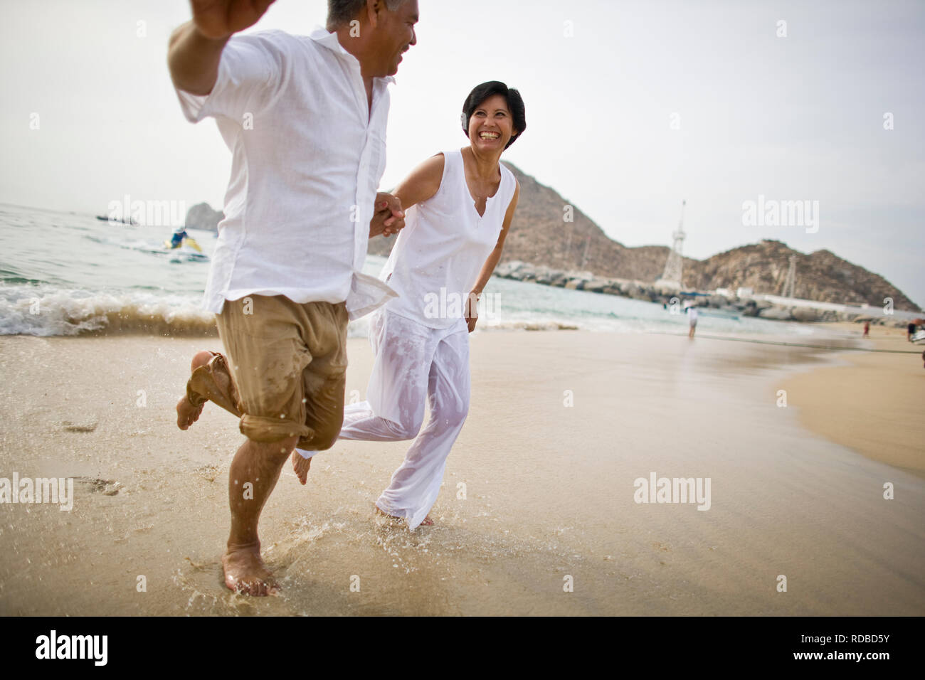 Reifes Paar spielen am Strand Stockfoto