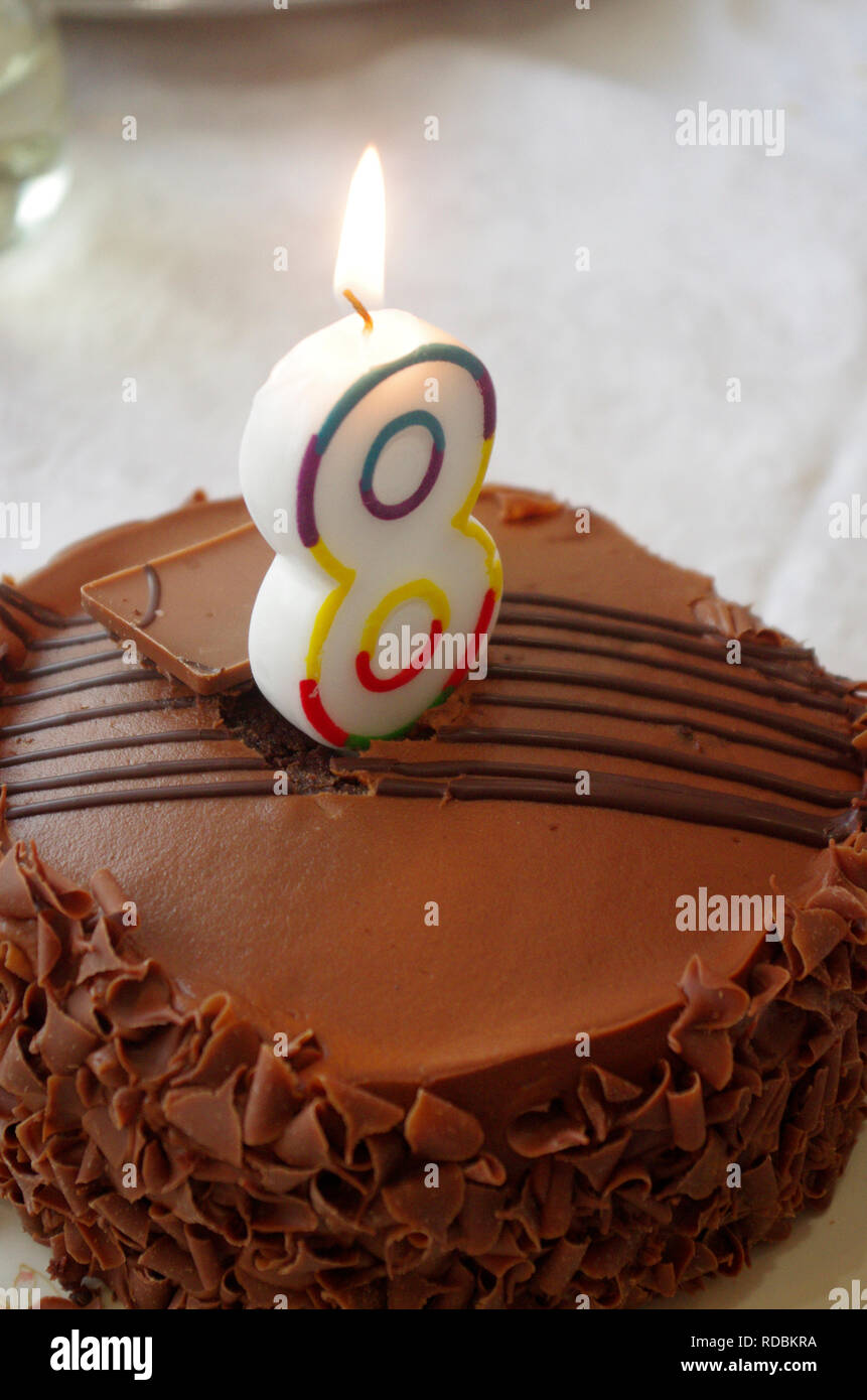 Das Kind das 8. oder 8. Geburtstag Kerze und Schokoladenkuchen Stockfoto