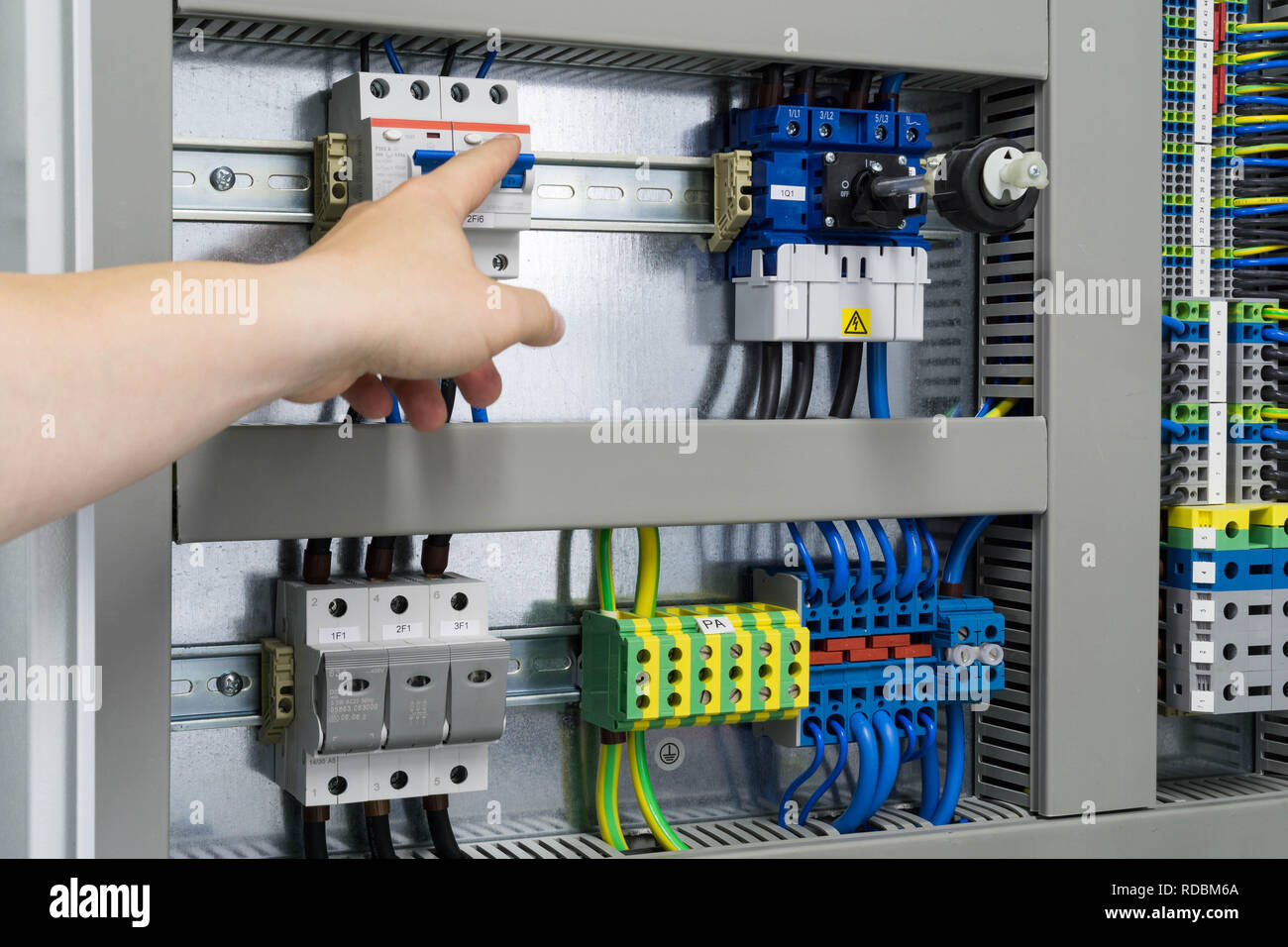 Hand in Richtung Sicherung im Sicherungskasten - Elektro- und Leittechnik  funktioniert Stockfotografie - Alamy