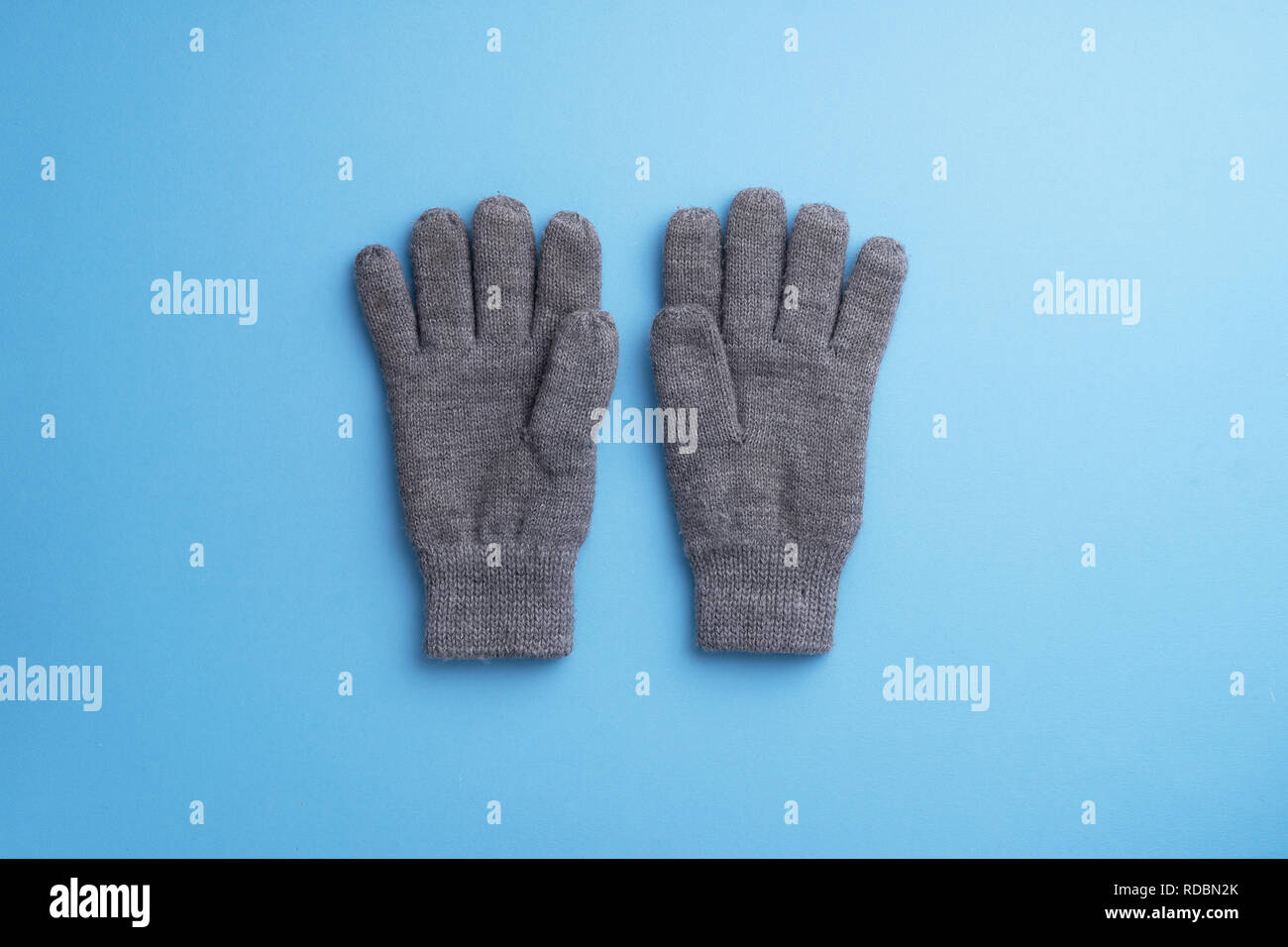 Stricken winter handschuhe über blauer Hintergrund Stockfoto