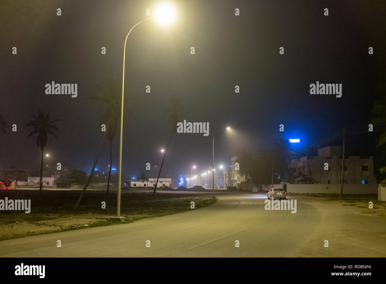Helle Straßenbeleuchtung leuchtenden Stille Vorstadtstraße in Salalah, südlichen Oman Stockfoto