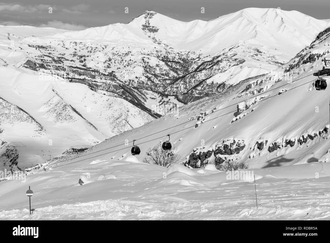 Verschneite Skipiste in Snowy Mountains und Gondelbahn auf Ski Resort. Kaukasus Berge an sonnigen Wintertag, Shahdagh, Aserbaidschan. Schwarz und whit Stockfoto