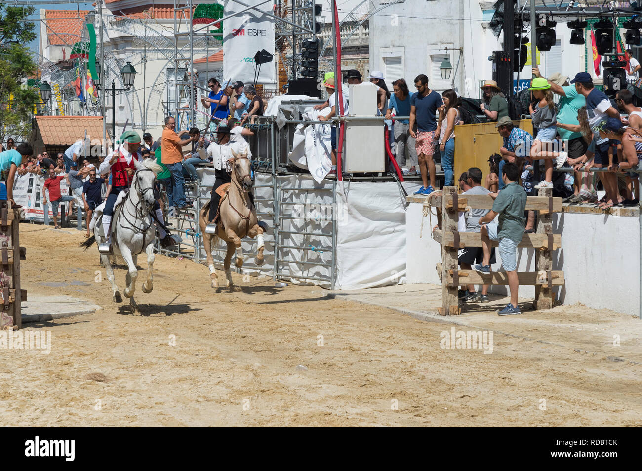 Wilde Bullen laufen und Reiter in den Straßen von Verbleitem, Festas do Barrete Verde e das Salinas, Provinz Alcochete, Setubal, Portugal Stockfoto