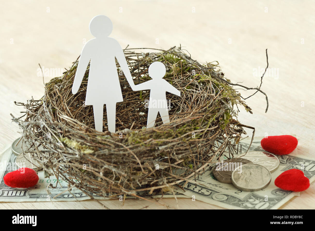 Papier Mutter und Sohn im Nest auf Geld und Herzen - Begriff der alleinerziehenden Elternteil Stockfoto