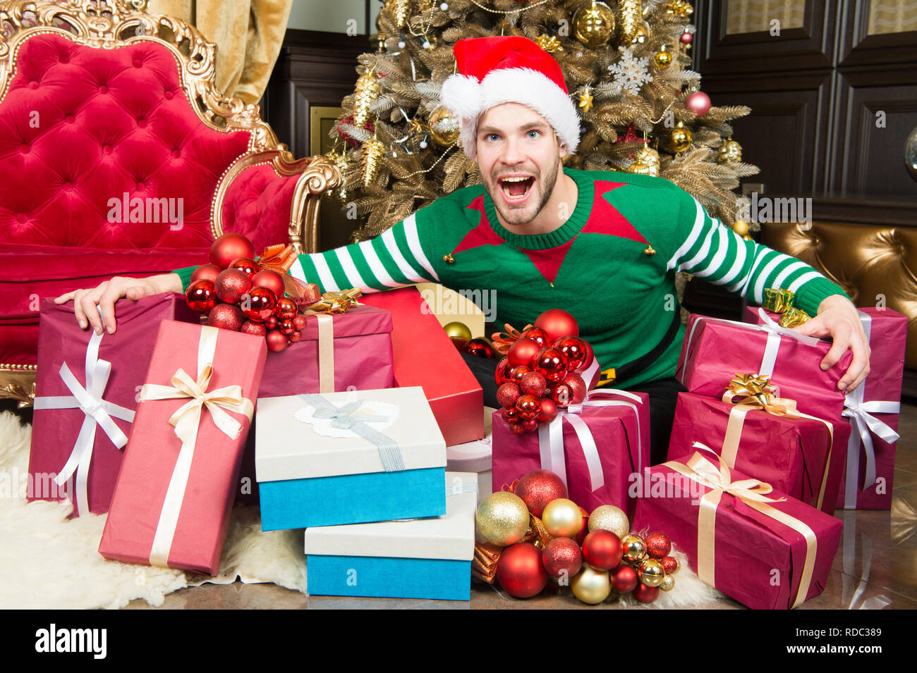 Frohes Neues Jahr und Frohe Weihnachten. Glückliche Menschen genießen das neue Jahr und die Weihnachtsfeier. Mann mit vorhanden Boxen durch Weihnachtsbaum. Die Welcome Party. Stockfoto