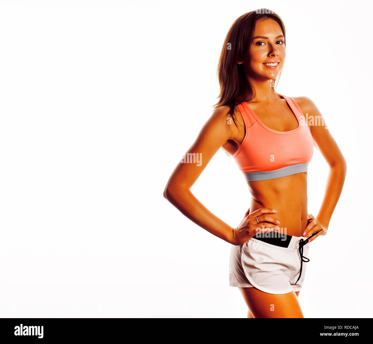 junge hübsche Frau in Sportbekleidung isoliert auf weißen Lächeln Stockfoto