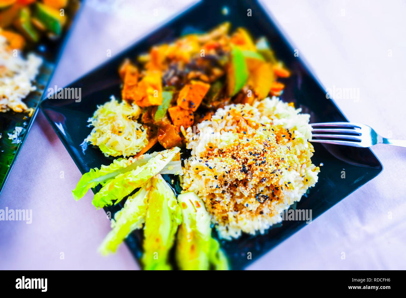 Der Kurs von braunem Reis mit gomashio (Sesam und Salz), Tempe mazeriert mit Gemüse, Römischer Salat und sauerkrautt. Makrobiotische Rezept. Stockfoto