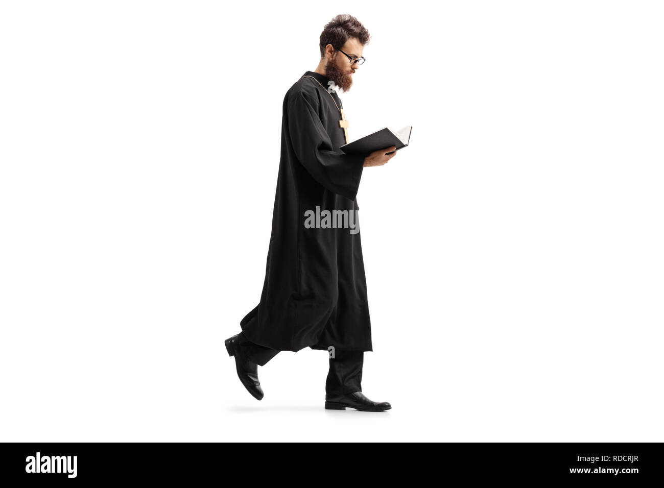 Volle Länge Schuß eines Priesters zu Fuß und das Lesen der Bibel auf weißem Hintergrund Stockfoto