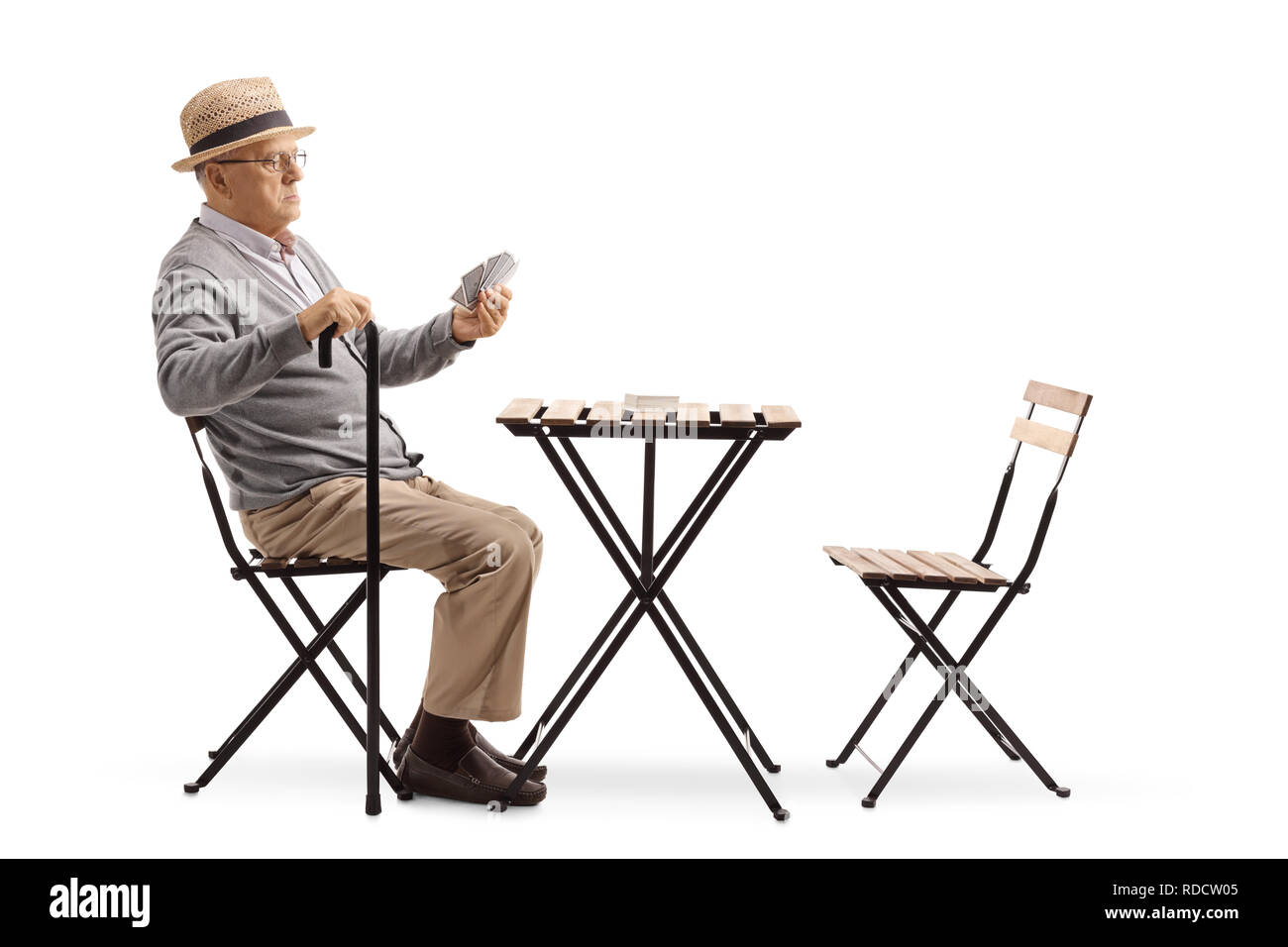 volle-lange-schuss-ein-alterer-mann-mit-einem-stock-an-einem-tisch-sitzen-und-karten-spielen-allein-isoliert-auf-weissem-hintergrund-rdcw05.jpg