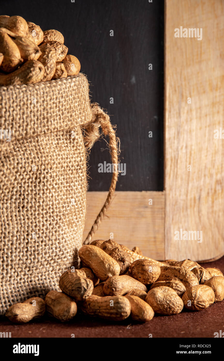 Sack Sack mit peanut auf braunem Hintergrund. Stockfoto