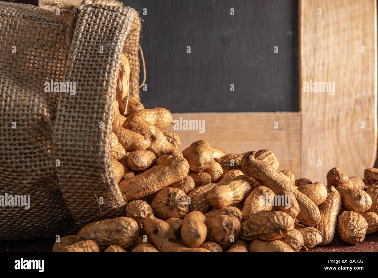 Sack Sack mit peanut auf braunem Hintergrund. Stockfoto