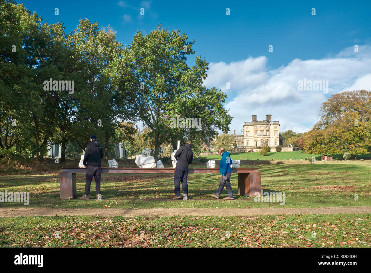 YORKSHIRE SCULPTURE PARK, Wakefield, W Yorks. 22 Okt, 2017. Drei männliche Besucher prüfen Skulpturen auf einer Bank vor der Bretton Hall angezeigt Stockfoto