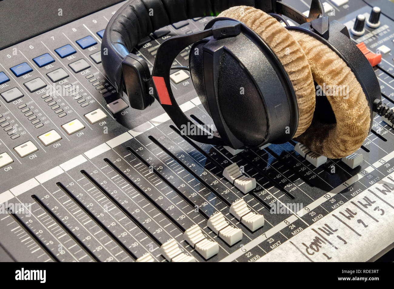 Kopfhörer sind auf dem Audio Controller im Aufnahmeraum platziert. Stockfoto