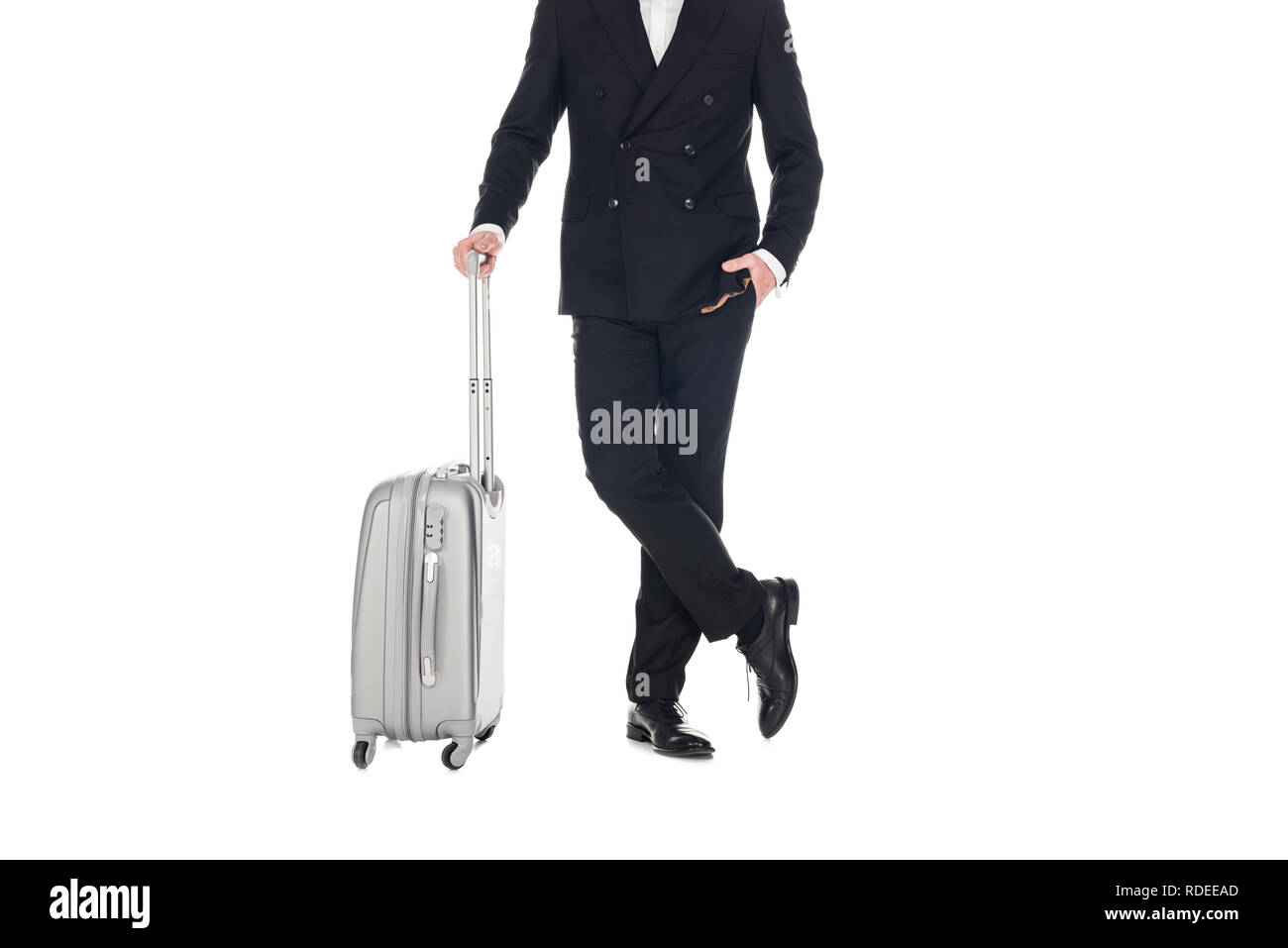 7/8-Ansicht der elegante Mann im schwarzen Smoking mit Travel Bag isoliert auf weißem Posing Stockfoto