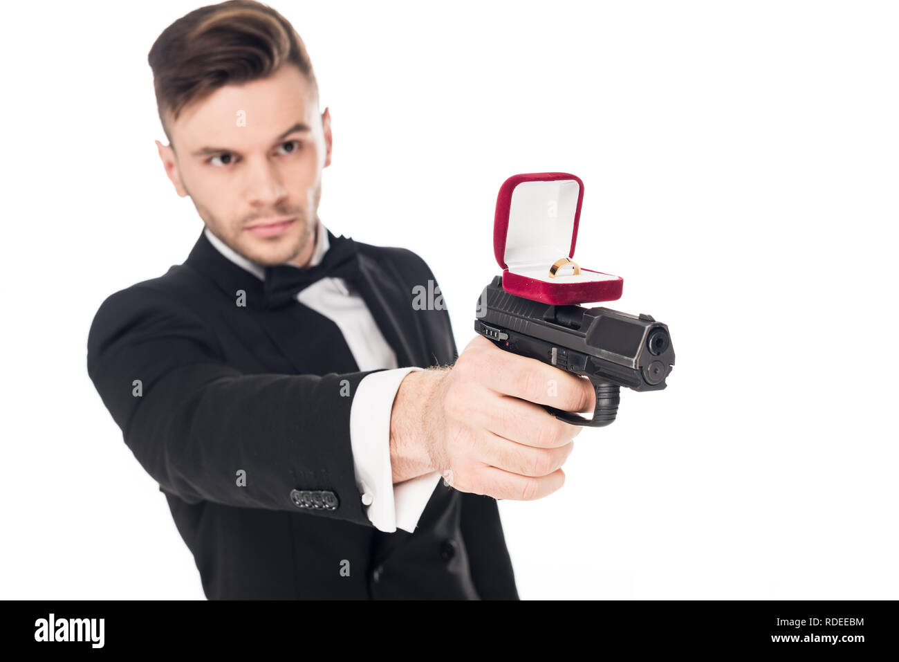 Männliche Killer im schwarzen Anzug mit Pistole mit Vorschlag ring, isoliert auf weißem Stockfoto