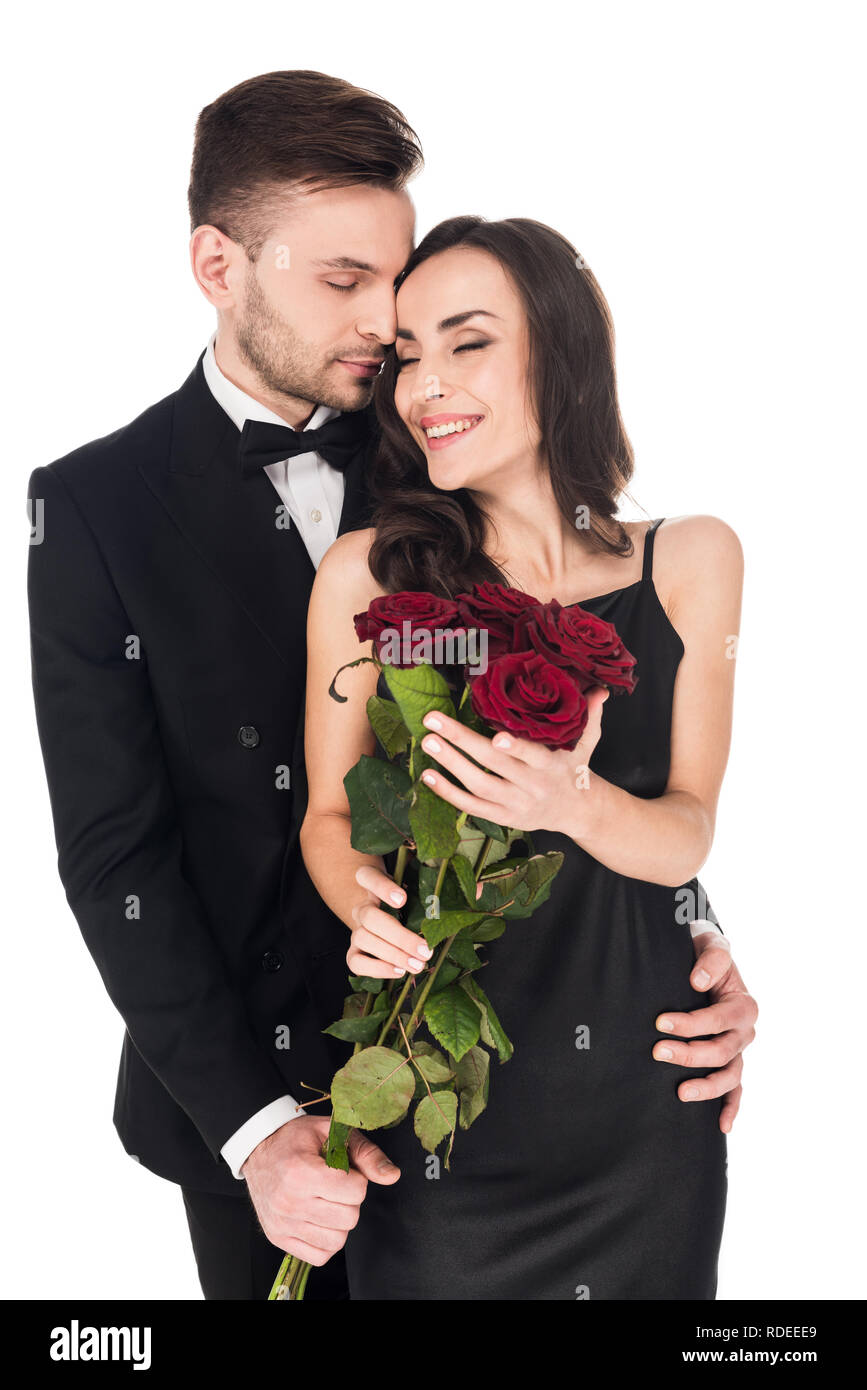 Glückliches Paar umarmen und posiert mit roten Rosen am Valentinstag, auf weissem isoliert Stockfoto