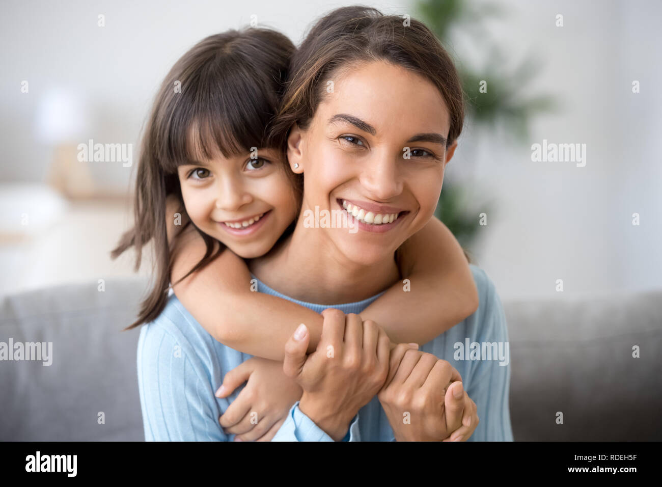 Glückliche Mutter und niedlichen Kind Tochter umarmen bei Camera suchen Stockfoto