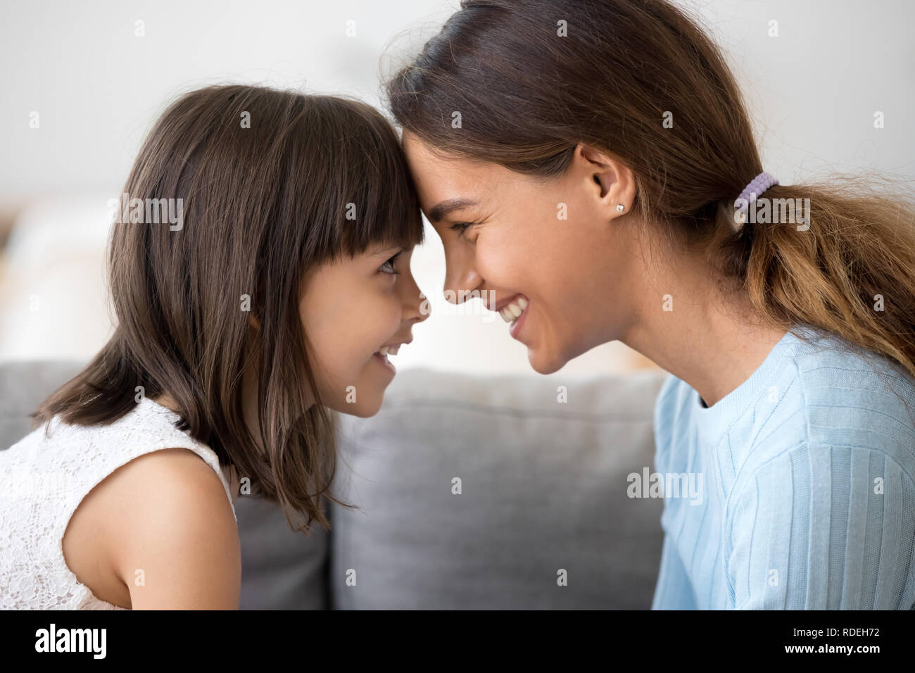 Cute kid Mädchen und Mama Berührung der Stirn in die Augen schauen, Stockfoto