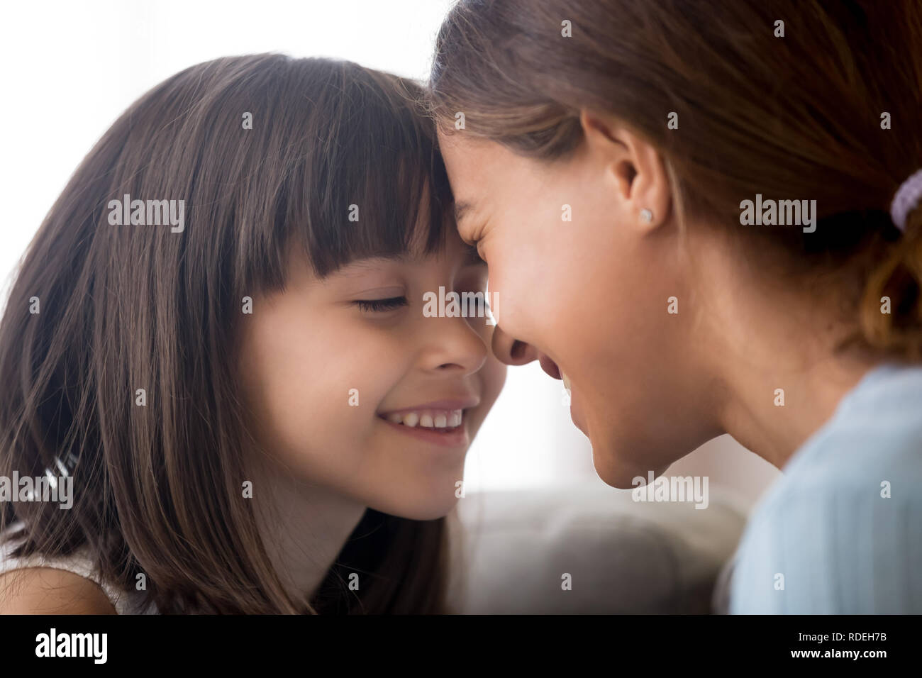 Lächelnd Kind Mädchen zärtlich Stirn berühren mit glücklich Stockfoto
