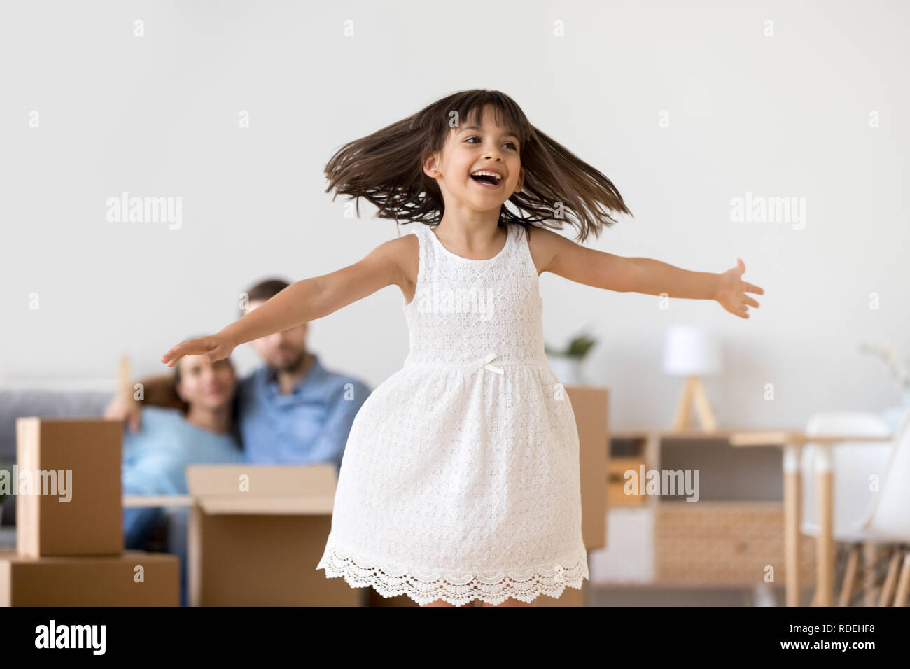 Lustige kleine Mädchen spielen Springen genießen Umzug in neues Zuhause Stockfoto