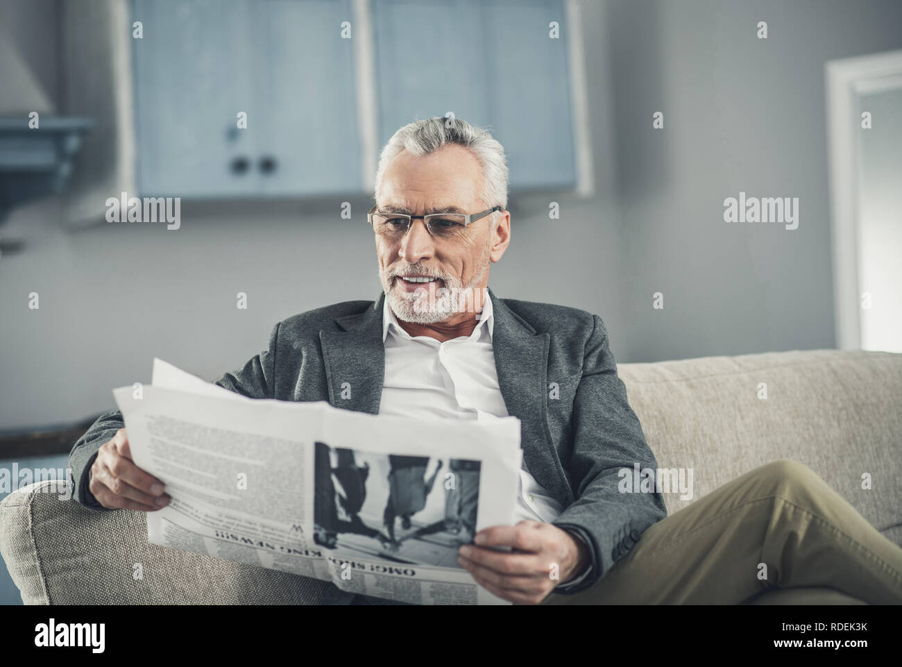 Grauhaariger mann Brille lesen positive Nachrichten Stockfoto