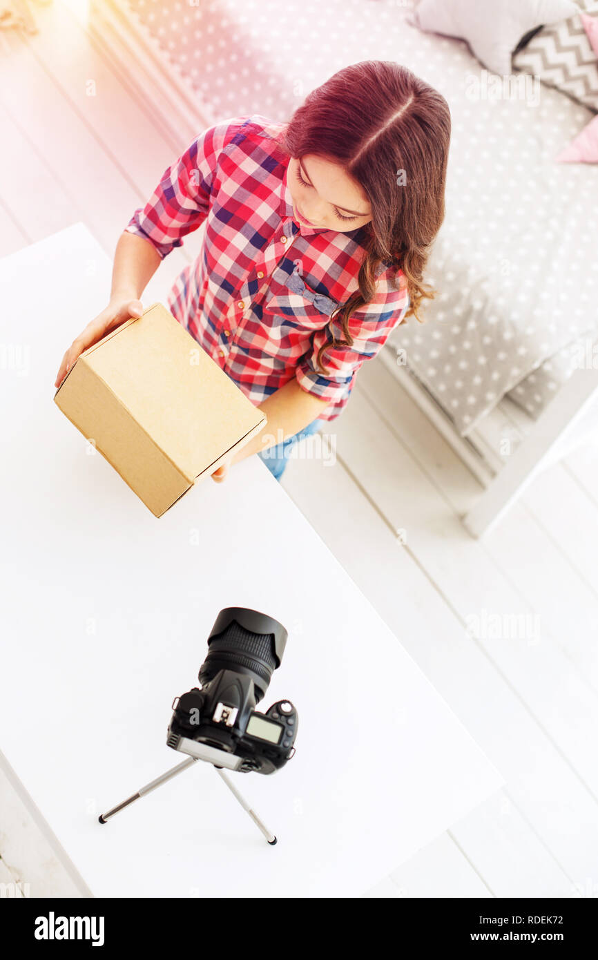 Nette und lustige kleine blogger Gefühl neugierig beim Erhalten ihr Geschenk Box Stockfoto