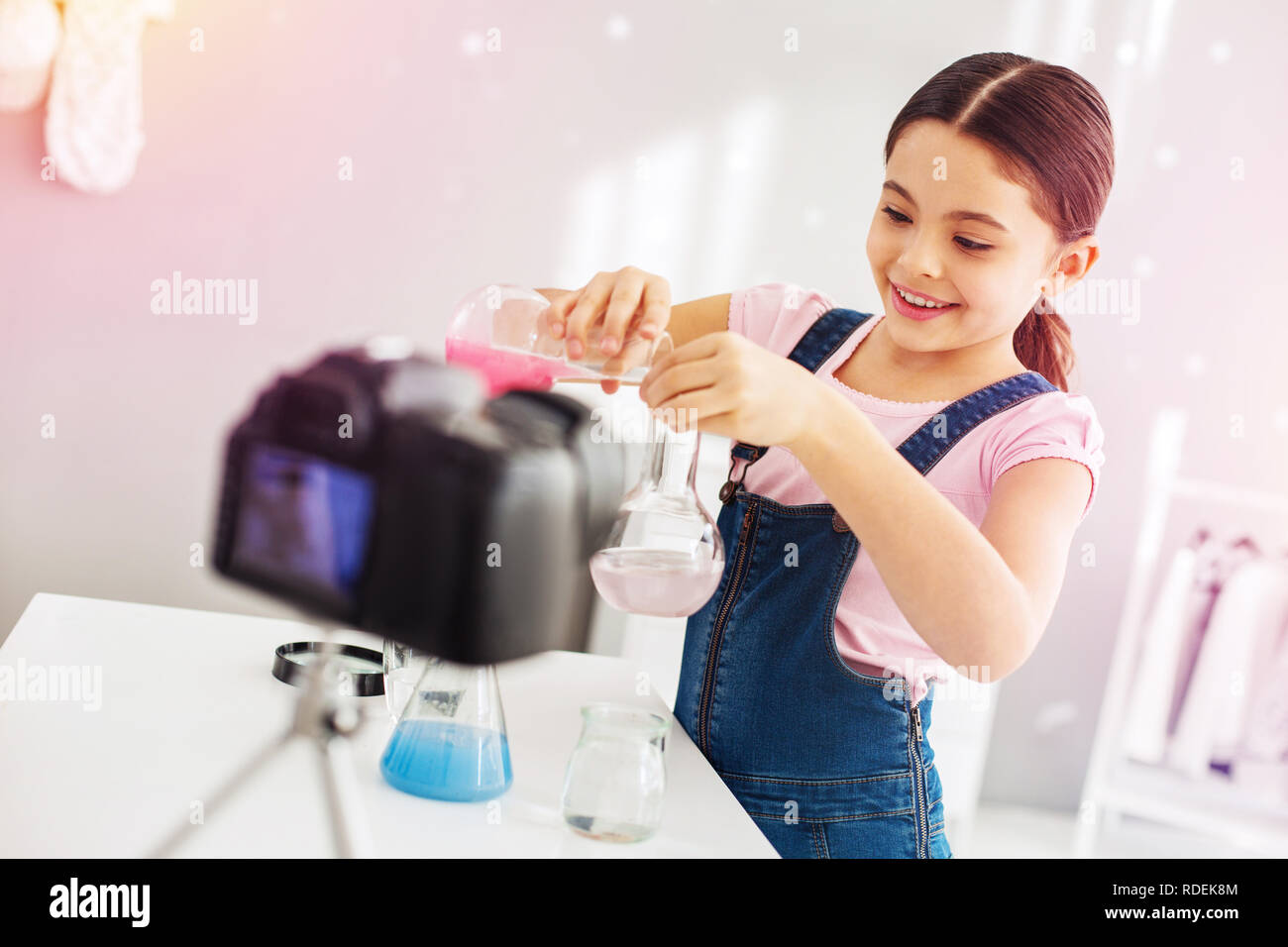 Dunkelhaarige Mädchen mit jumpsuit Gefühl aufgeregt, Chemie experiment Stockfoto