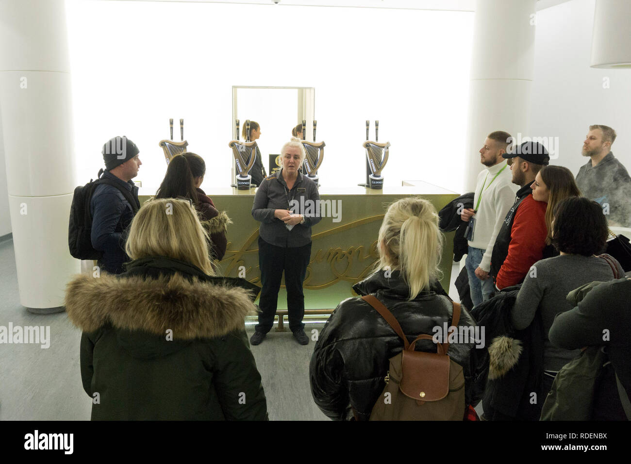 Ein Reiseleiter spricht als Besucher erfahren, wie Guinness Brauerei im Guinness Storehouse in Dublin, Irland, 15. Jan 2019 zu trinken. Stockfoto