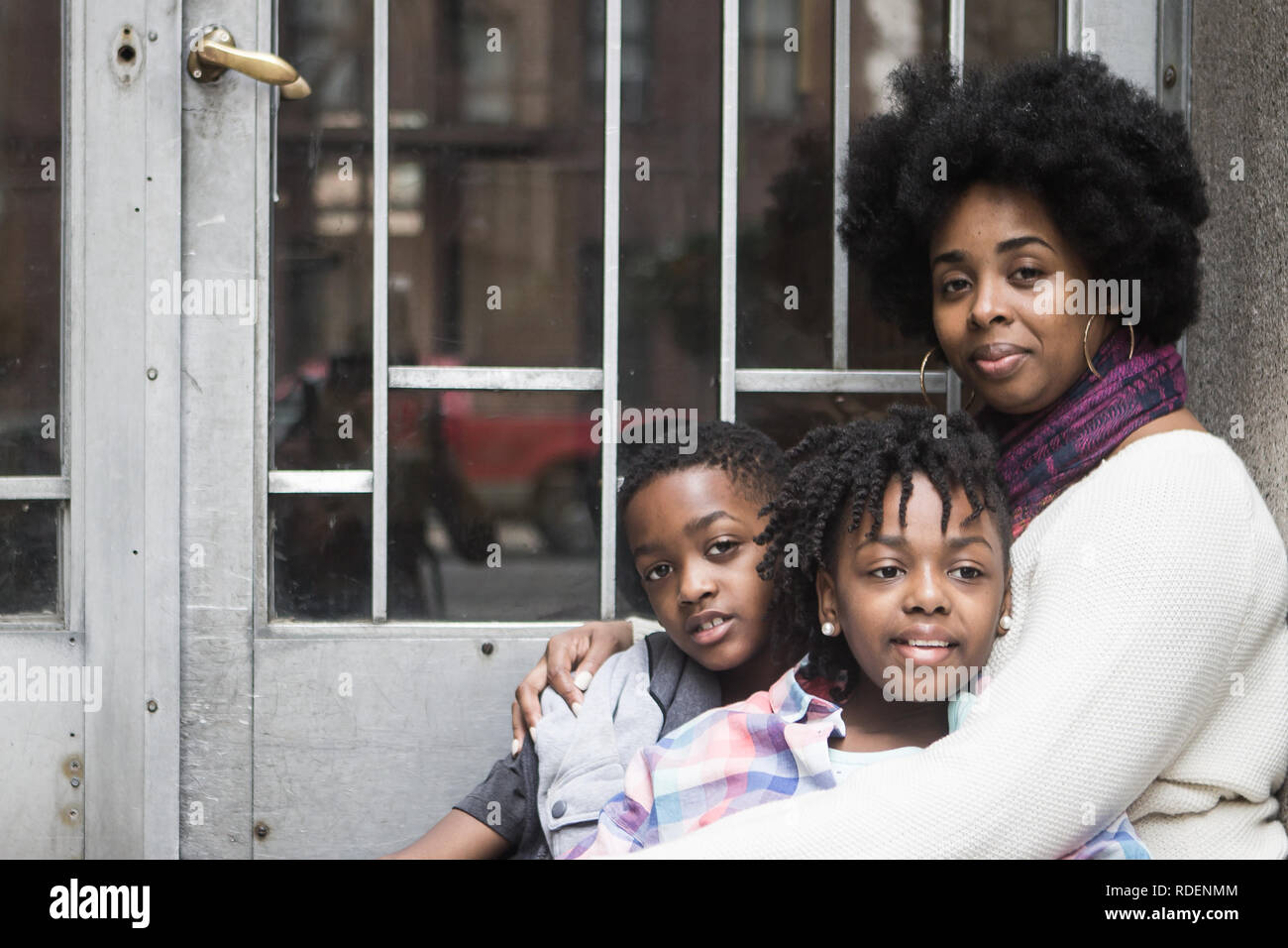 Afrikanische amerikanische Mutter mit Kindern draußen sitzen lächeln Stockfoto