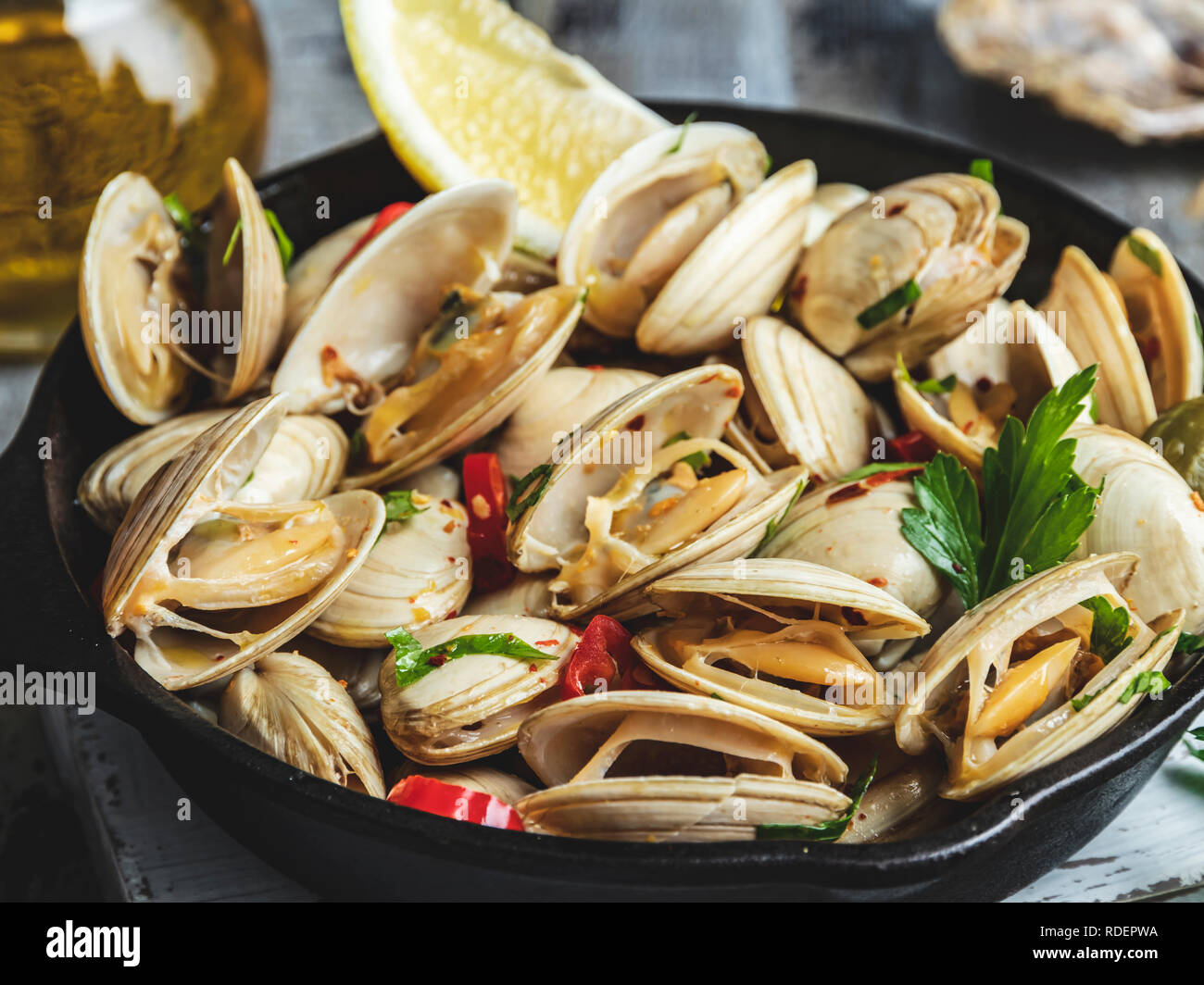 Gekochte Meeresfrüchte Muscheln in der eiserne Pfanne Teil mit Zitrone und Gewürzen Stockfoto