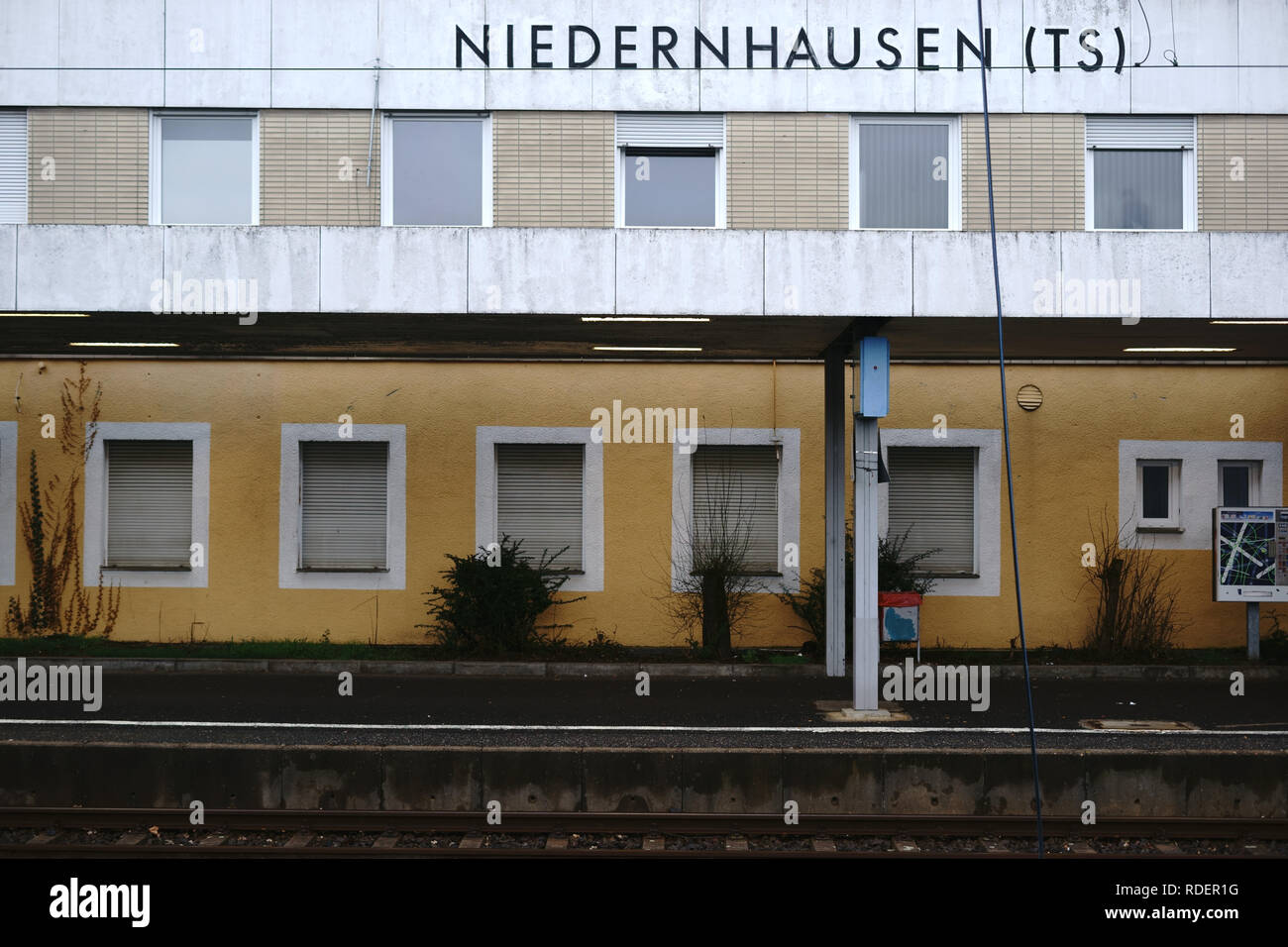 Ein leeres Bahnhofsgebäude der Bahnhof Niedernhausen mit vergitterten Fenstern und eine klinkerfassade. Stockfoto