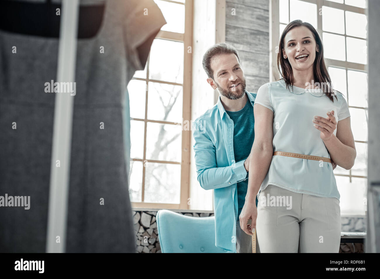 Mann arbeitete als Modedesignerin messen Taillenweite von Frau Stockfoto