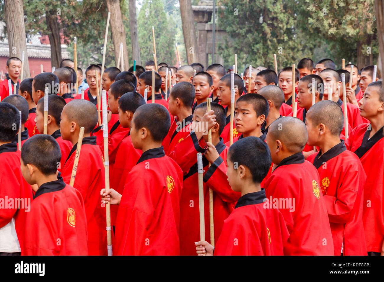 Dengfeng, China - Oktober 16, 2018: Schüler der Kampfkunst Schule stand mit der Schlacht Polen und hören Sie Ihrem Lehrer. Shaolin Tempel. Stockfoto