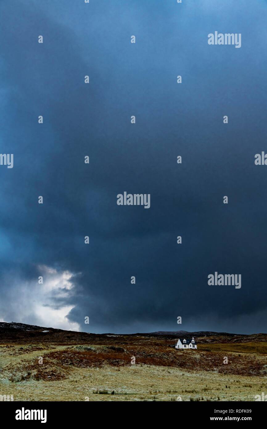Kleines Haus vor einem dunklen storm Cloud, Broadford, Isle of Skye, Großbritannien Stockfoto