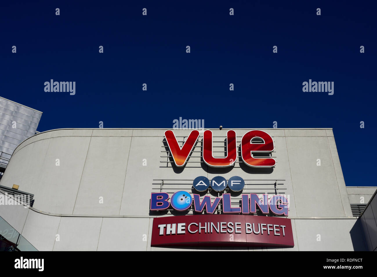 Vue Cinema-Logo, Schild, amf-Bowling und die außenbeschilderung des chinesischen Buffets, die an einem aluminiumverkleideten Gebäude mit klarem blauen Himmel in Bury, lancashire, großbritannien, befestigt ist Stockfoto