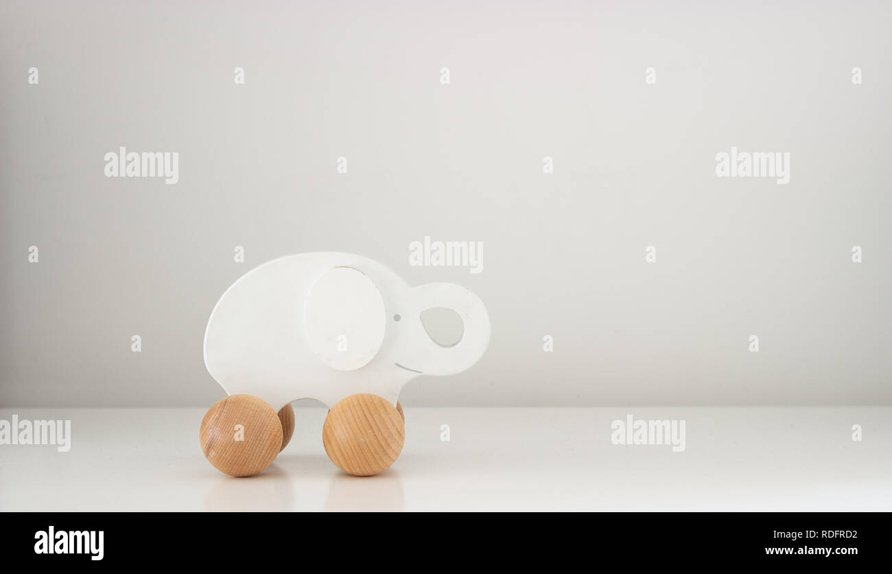 Eine hölzerne weiß Spielzeug Elefant auf vier Rädern auf einen weißen Hintergrund mit Kopie Raum isoliert, Stockfoto