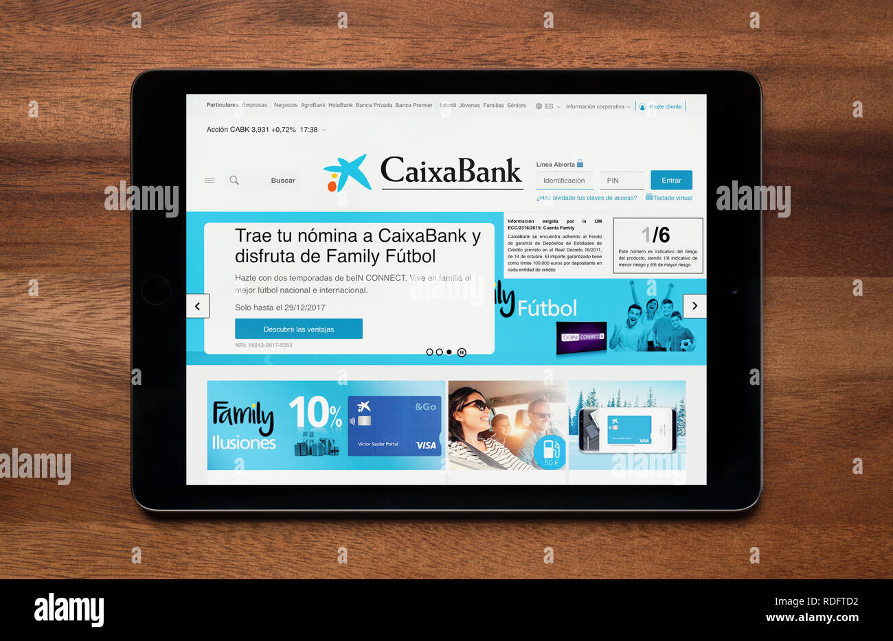 Die Website der CaixaBank gesehen auf einem iPad Tablet, der ruht auf einem Holztisch (nur redaktionelle Nutzung). Stockfoto