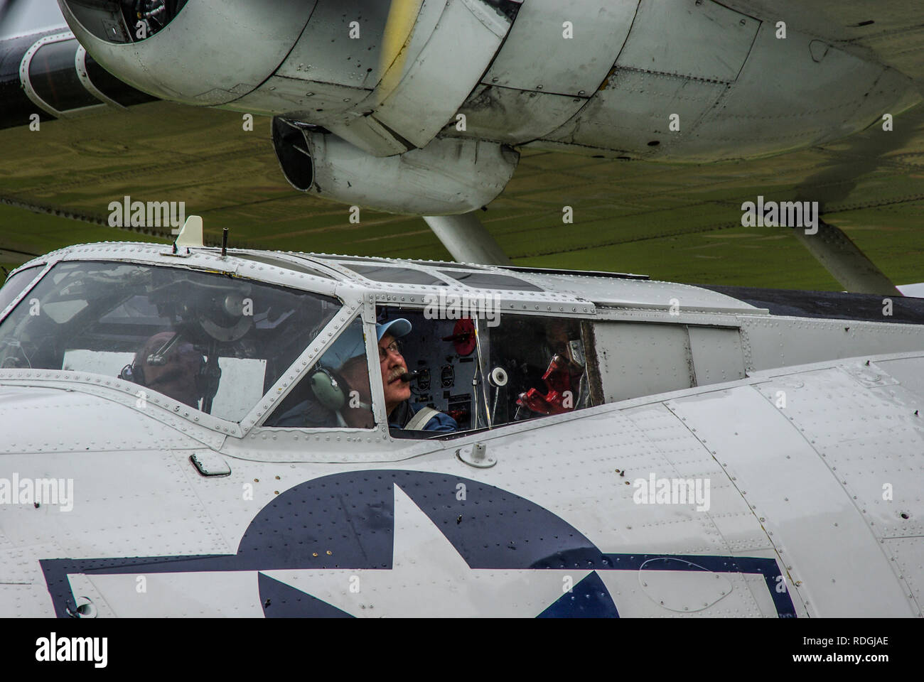 Konsolidiertes Flugzeug des Flugzeugs Catalina aus dem Zweiten Weltkrieg, das in Betrieb genommen wurde. Pilot sieht auf den Motor Stockfoto