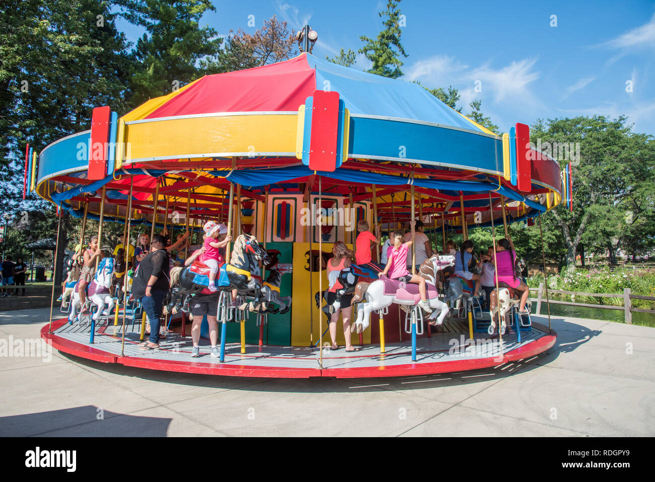 Aurora, Illinois, United States-August 9, 2017: Eltern und Kinder auf dem Karussell fahren an einem sonnigen Tag an Blackberry Farm in Aurora, Illinois Stockfoto