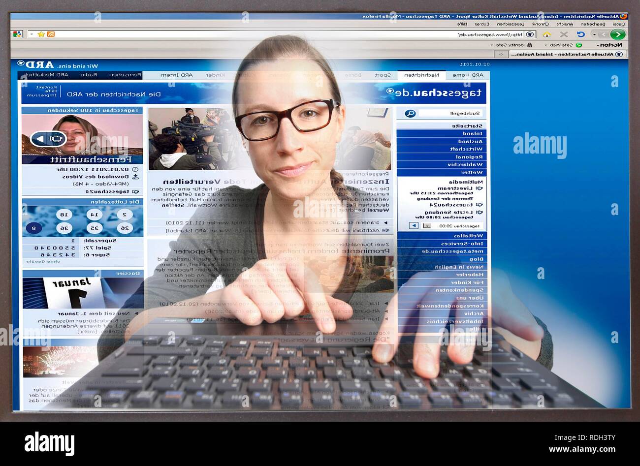 Junge Frau an einem Computer beim Surfen im Internet, Anzeigen einer Seite der ARD-Tagesschau, Deutsche Nachrichten des Tages Stockfoto