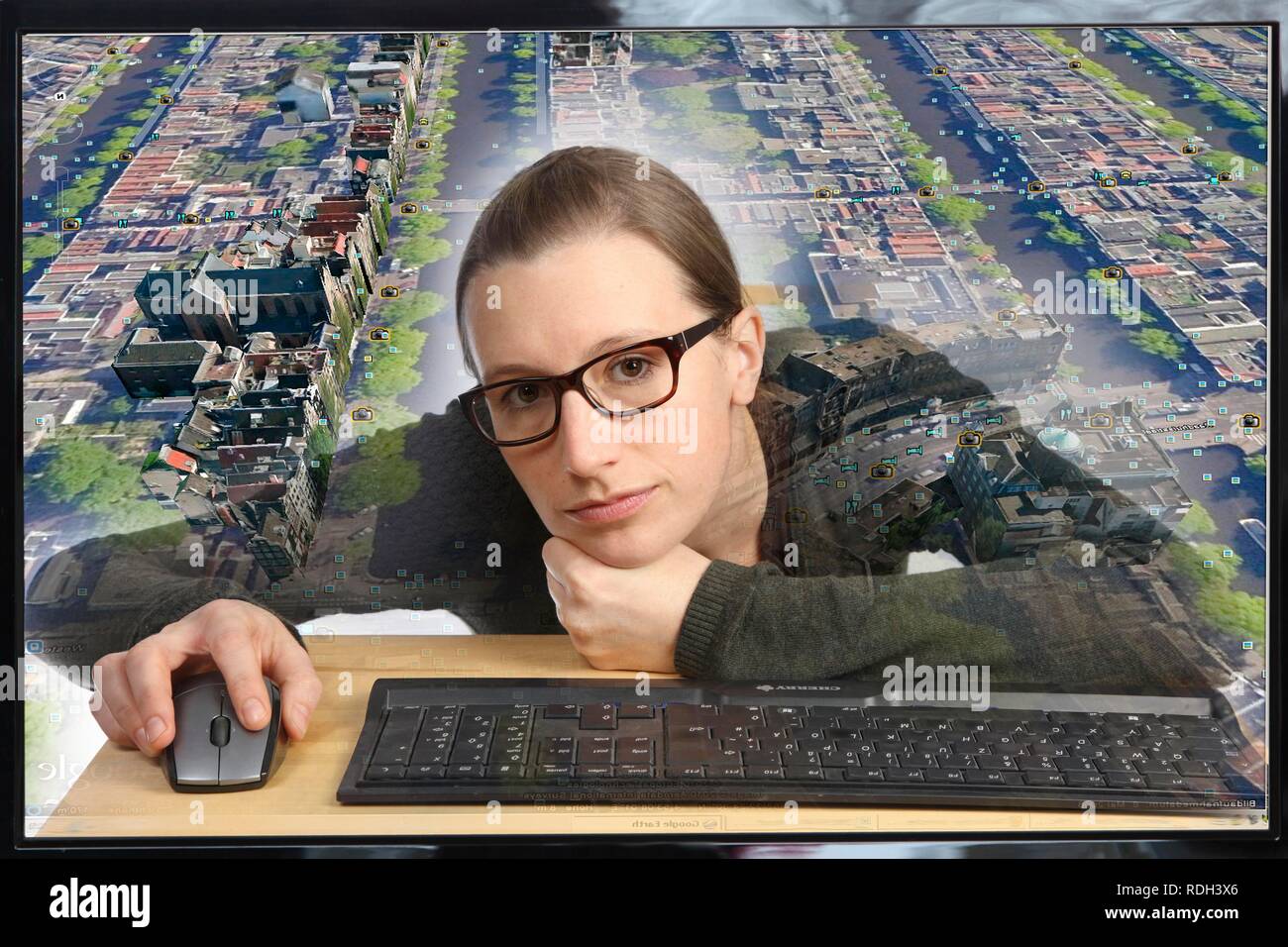 Junge Frau an einem Computer mit Google Street View sitzen, Detailgenauigkeit mit einem Abschnitt der Stadt Amsterdam, Menschen und Stockfoto