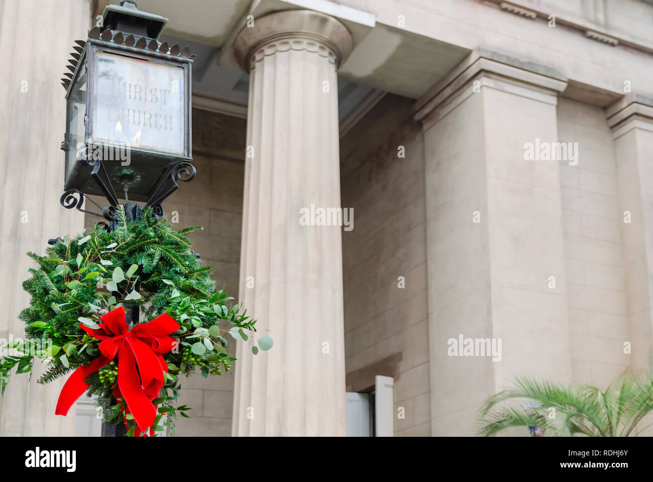 A Christmas wreath hängt von einem Post an der Christ Church Cathedral, Dez. 23, 2018 in Mobile, Alabama. Die Kirche wurde im Jahre 1823 errichtet. Stockfoto