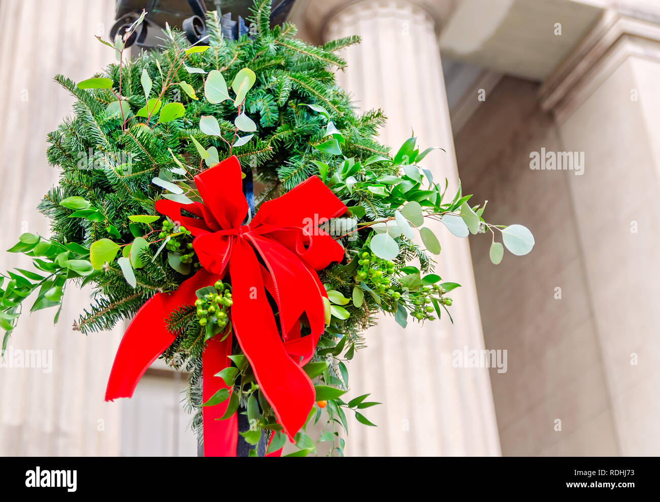 A Christmas wreath hängt von einem Post an der Christ Church Cathedral, Dez. 23, 2018 in Mobile, Alabama. Die Kirche wurde im Jahre 1823 errichtet. Stockfoto